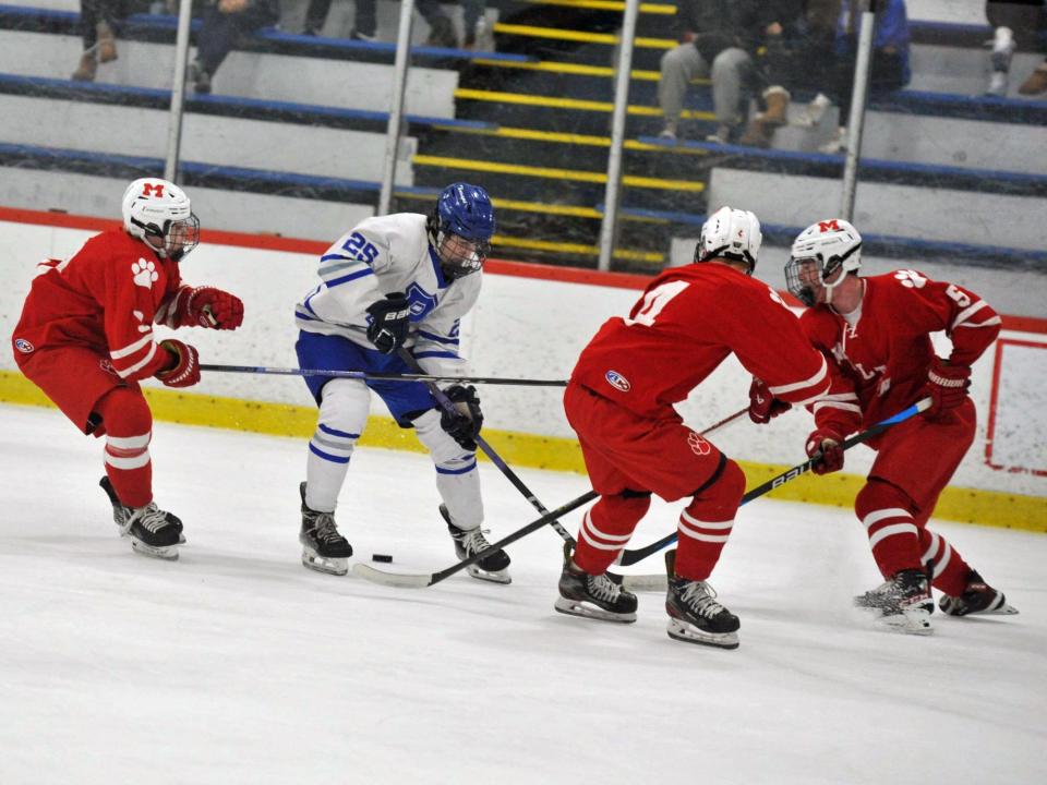 Braintree's Andrew Gaffney, second from left, is surrounded by Milton defenders from left, Ben Doak, Aidan Rowley and Harry Hinckle, during boys high school hockey at the Zapustas Ice Arena in Randolph, Tuesday, Jan. 10, 2024.