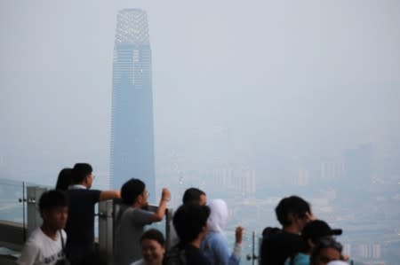 Tourists look at the city skyline shrouded by haze at Kuala Lumpur Tower in Kuala Lumpur