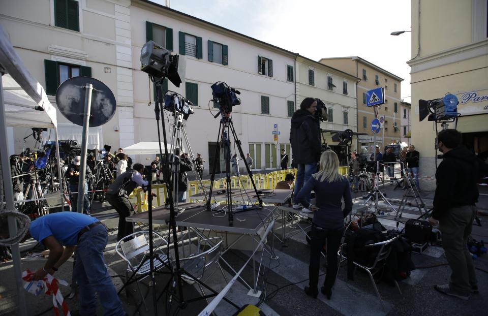 Journalist prepare their equipment in front of the Teatro Moderno theater where the first hearing of the trial for the Jan. 13, 2012 tragedy, where 32 people died after the luxury cruise Costa Concordia was forced to evacuate some 4,200 passengers after it hit a rock while passing too close to the Giglio Island, is taking place, in Grosseto, Italy, Monday Oct. 15, 2012. (AP Photo/Gregorio Borgia)