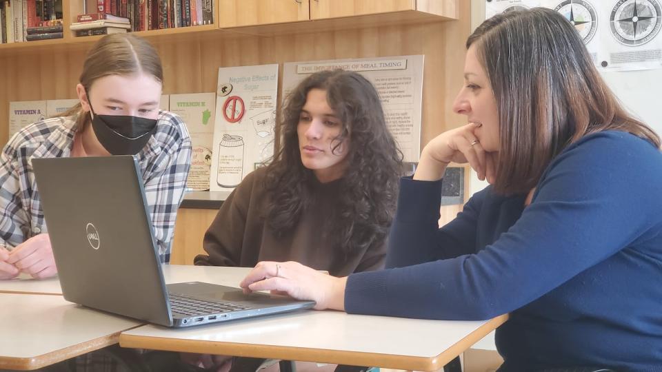 Fredericton social studies teacher Laura McCarron, right, shows senior high school students Declan DeWolfe, centre, and Annie McCaskill online videos from the CIVIX Ctrl-F: Find the Facts verification skills program. 