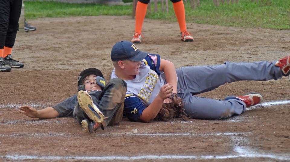 The Village's Wyatt Paul slides safely home in a close play at the plate Wednesday during the 12u baseball championship
