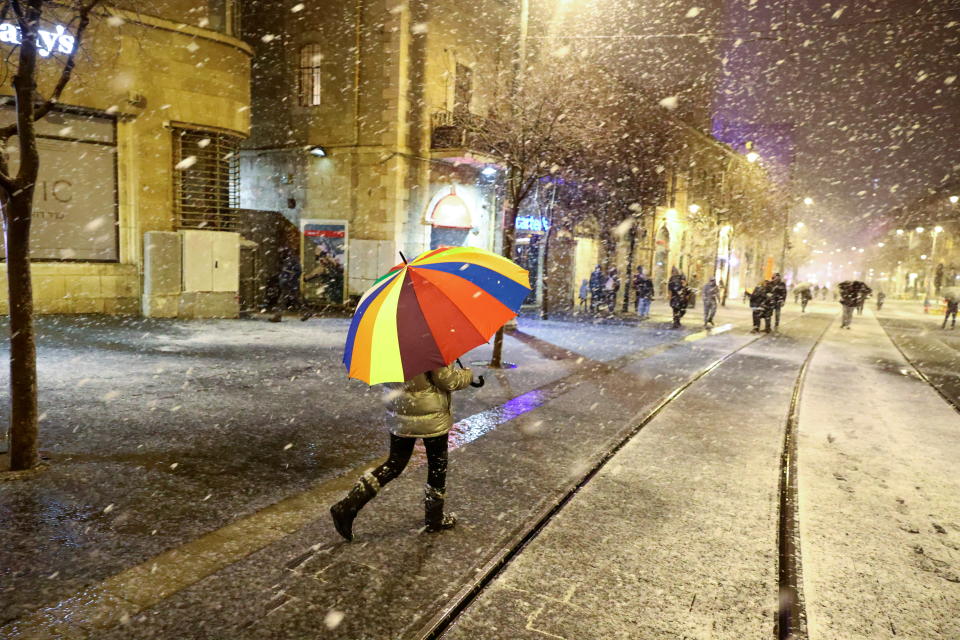 <p>A person walks with an umbrella as the first snow starts to settle during a snowstorm in Jerusalem, January 26, 2022. REUTERS/Ronen Zvulun</p>
