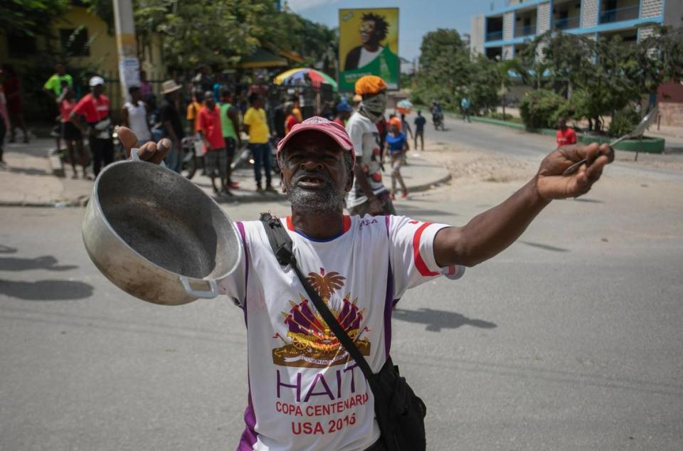 A protester prays outside St Peter’s Church as he holds a pot and a spoon in his hands during a protest to demand the resignation of Prime Minister Ariel Henry in the Petion-Ville area of Port-au-Prince, Haiti, Monday, Oct. 3, 2022.