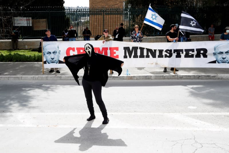 An Israeli woman wears a costume during a demonstration against PM Netanyahu's caretaker government in Jerusalem