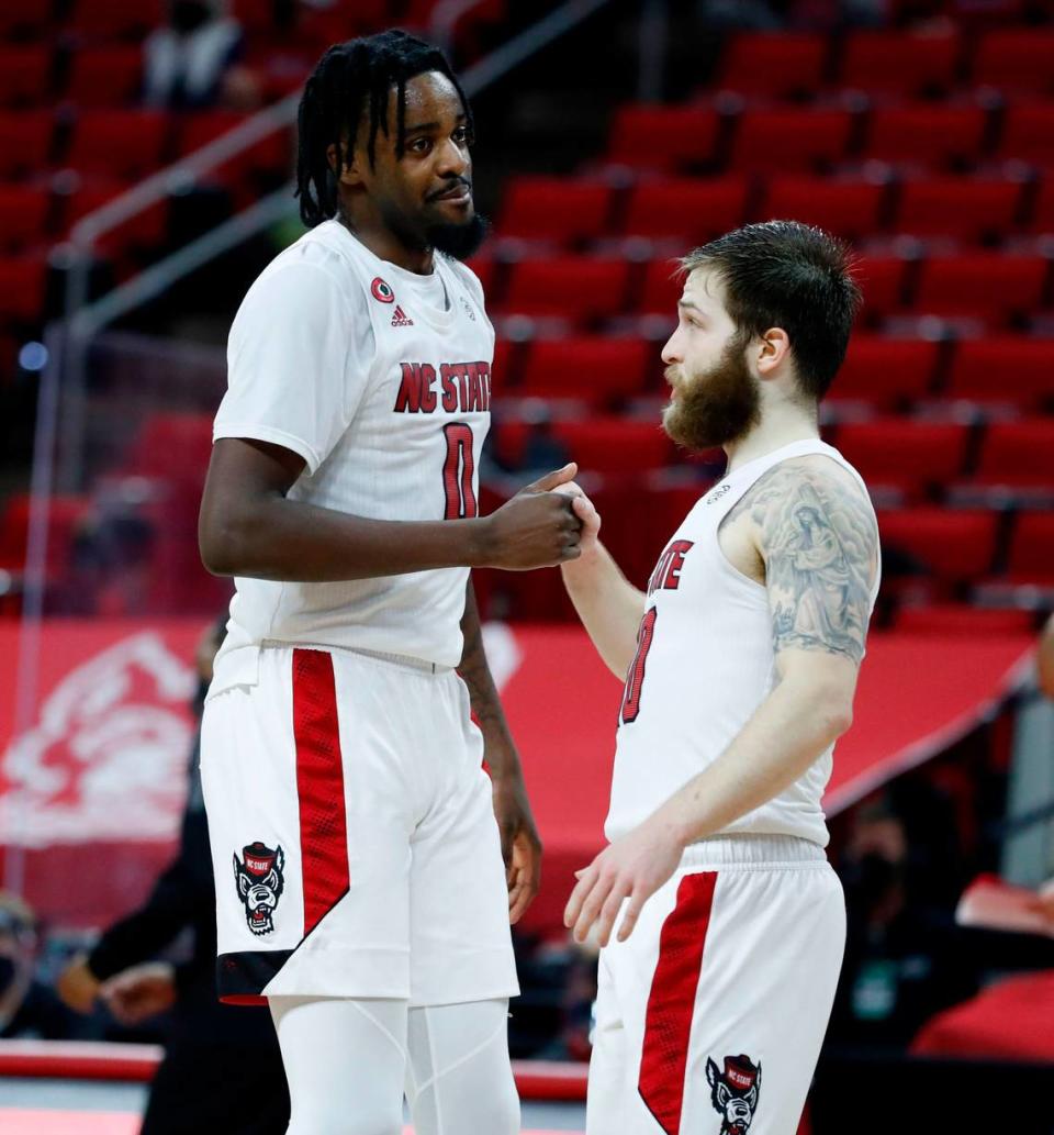 N.C. State’s D.J. Funderburk (0) and Braxton Beverly (10) talk during the second half of N.C. State’s 65-62 victory over Pittsburgh at PNC Arena in Raleigh, N.C., Sunday, February 28, 2021.