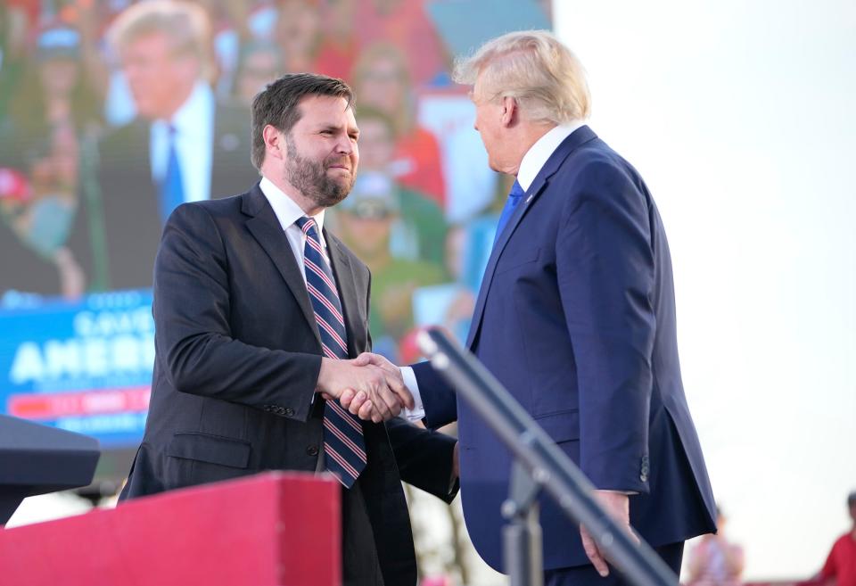 JD Vance shakes hands with former President Donald Trump during a rally at the Delaware County Fairgrounds on April 23.