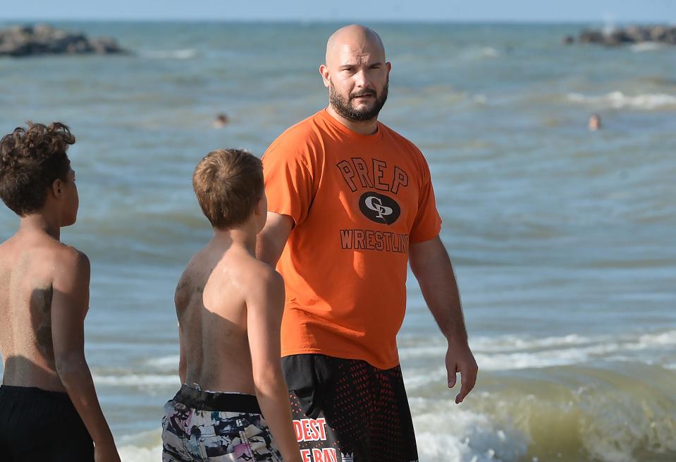 Rambler Wrestling Club assistant coach Mark Harrington, 38, leads a workout at Presque Isle State Park Beach 7.