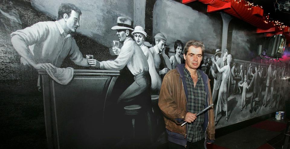 Barberton artist Ralph Herzog stands in front of his almost finished mural depicting local characters on the wall of the Innfield Inn on Monday, Feb. 4, 2008, in Barberton, Ohio. (Paul Tople, Akron Beacon Journal)