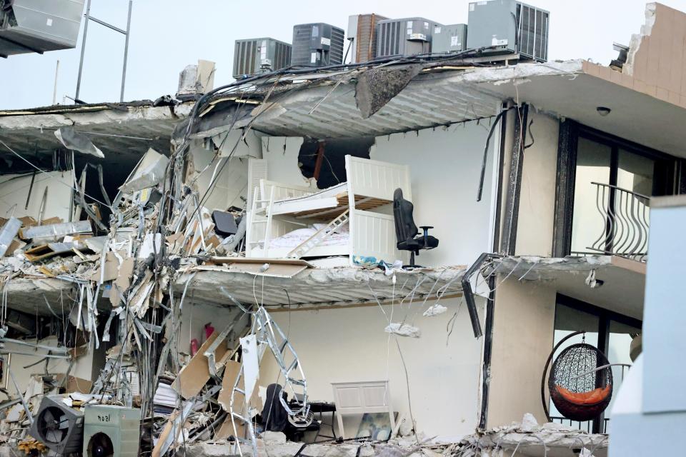 Debris dangles from Champlain Towers South Condo after the multistory building partially collapsed Thursday, June 24, 2021, in Surfside, Fla.