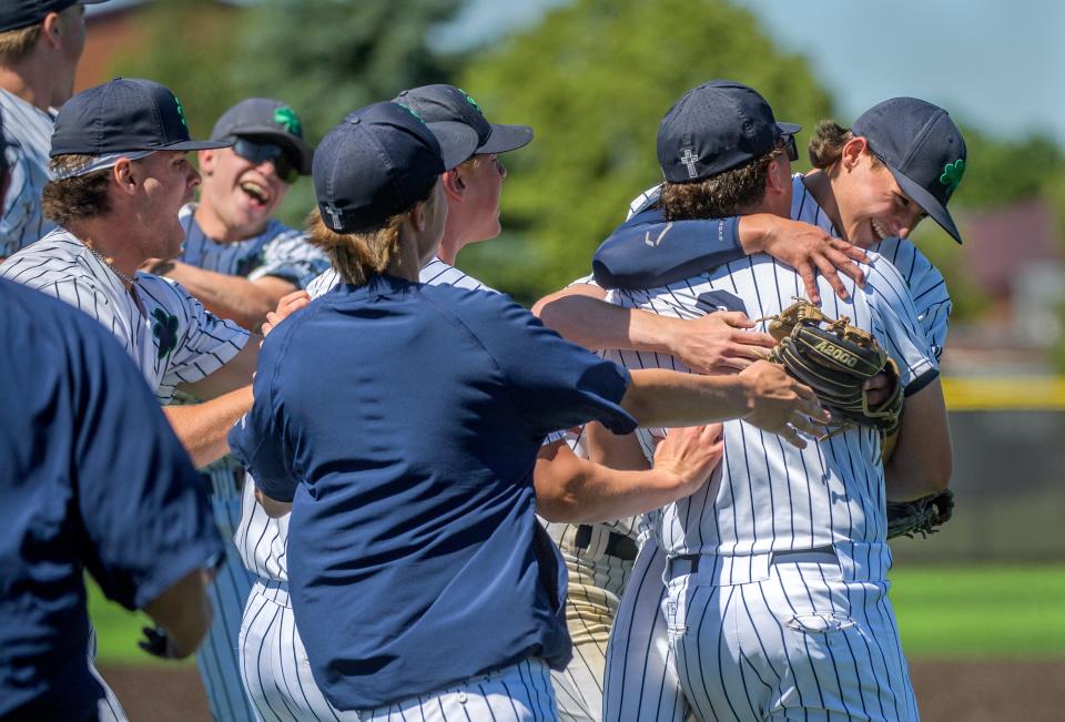 Teammates mob Peoria Notre Dame pitcher Jack Livengood, facing, and first baseman Jackson Campbell after their 2-0 win over Illini West in the Class 2A baseball sectional title game Saturday, May 25, 2024 in Chillicothe. The Irish advanced to face Wilmington at 1 p.m. Monday in the Geneseo Supersectional.