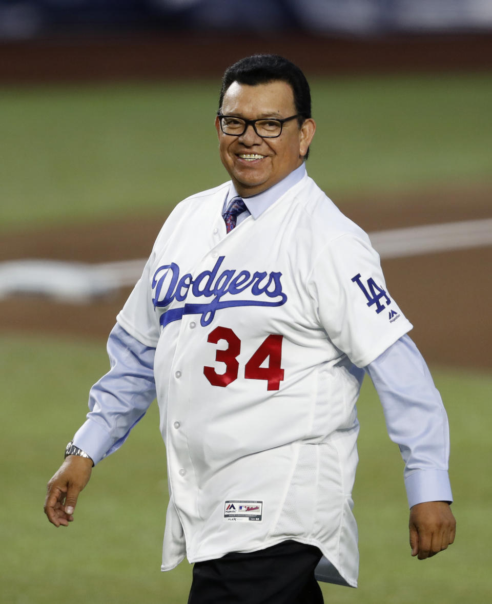 FILE - In this May 4, 2018, file photo, retired Major League Baseball pitcher Fernando Valenzuela smiles as he walks to make a ceremonial first pitch before a game between the San Diego Padres and the Los Angeles Dodgers, in Monterrey, Mexico. The Dodgers needed a strike interrupted season and a pitching sensation named Fernando Valenzuela to win a championship in 1981. More important for the Dodgers, perhaps, is that they found a way that year to connect with Hispanic fans who nearly four decades later are still loyal supporters of the team. Author Jason Turbow tells PodcastOne Sports Now that the season was significant in many ways for the Dodgers, something he details in his new book ``They Bled Blue,'' a recap of a season like no other. (AP Photo/ Eduardo Verdugo, File)