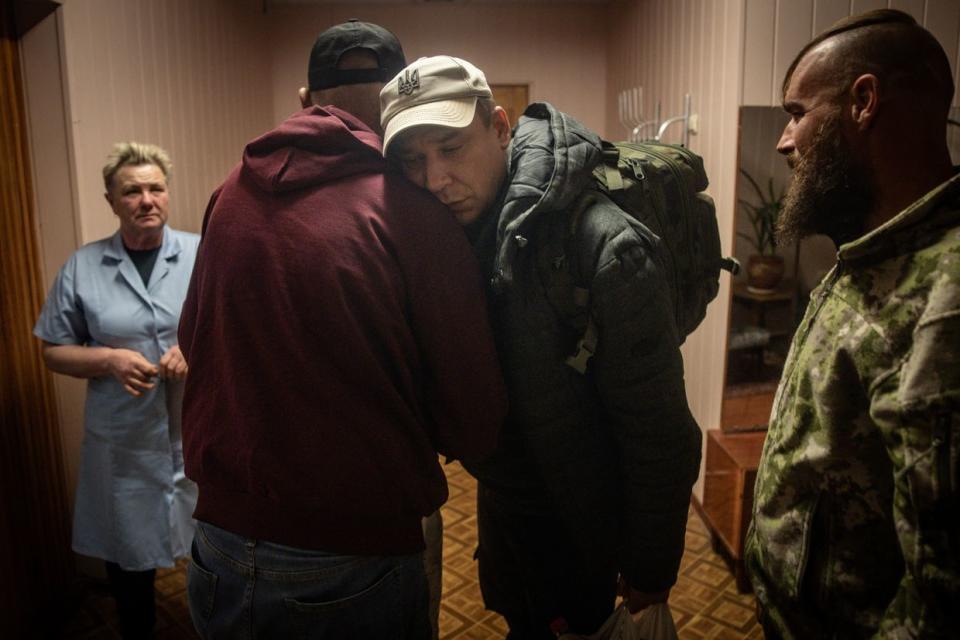 Oleksandr, a 45-year-old Ukrainian soldier, hugs a friend as he says goodbye and leaves an apartment after finishing his treatment at a psychiatric hospital in Kyiv, Ukraine, on Oct. 11, 2023. (Chris McGrath/Getty Images)