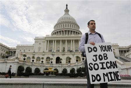 A furloughed federal employee holds a sign on the steps to the U.S. Capitol after the U.S. Government shut down last night, on Capitol Hill in Washington October 1, 2013. REUTERS/Larry Downing