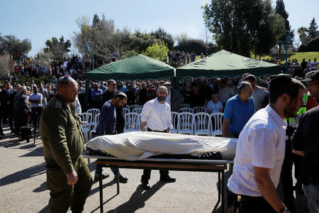 Relatives and friends mourn as they stand next to the body of Israeli rabbi Achiad Ettinger, wrapped in a Jewish prayer shawl, during his funeral, in the Jewish settlement of Eli in the Israeli-occupied West Bank March 18, 2019. REUTERS/Ronen Zvulun