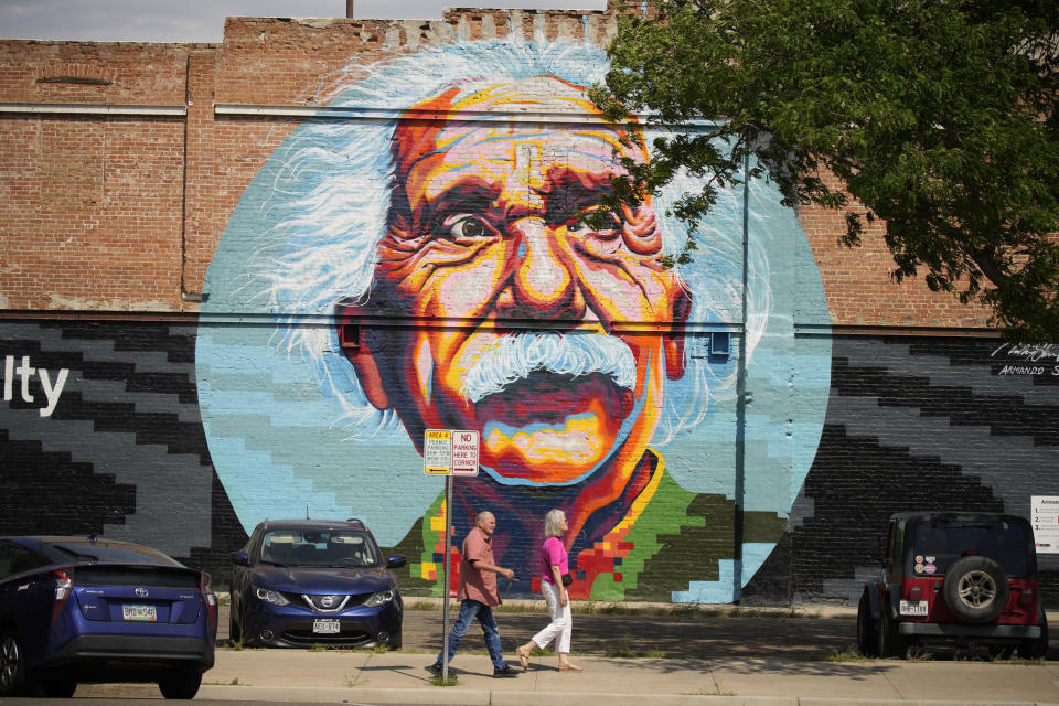 In this Friday, July 23, 2021, photograph, a mural of Albert Einstein looks on as residents walk down a downtown sidewalk in Greeley, Colo. Figures released this month show that population growth continues unabated in the South and West, even as temperatures rise and droughts become more common. That in turn has set off a scramble of growing intensity in places like Greeley to find water for the current population, let alone those expected to arrive in coming years. (AP Photo/David Zalubowski)