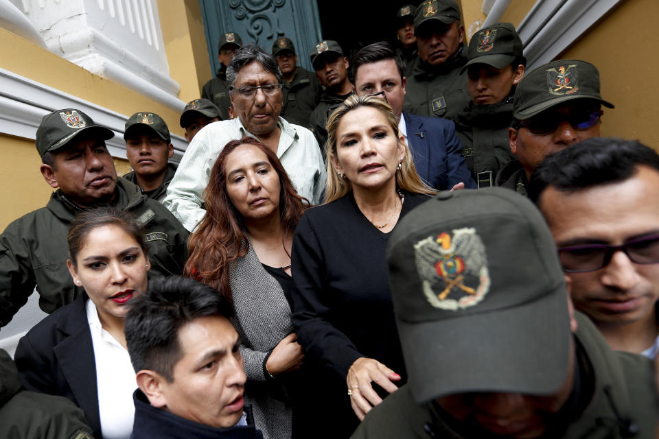 Senate second Vice President Jeanine Anez, center right, arrives to Congress in La Paz, Bolivia, Monday, Nov. 11, 2019. Bolivian President Evo Morales' Nov. 10 resignation, under mounting pressure from the military and the public after his re-election victory triggered weeks of fraud allegations and deadly demonstrations, leaves a power vacuum and a country torn by protests against and for his government. (AP Photo/Natacha Pisarenko)