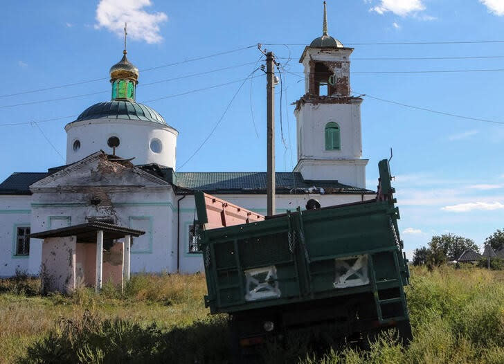 Una iglesa dañada por bombardeos junto a un vehículo destruido marcado con la "Z" de la invasión rusa en la localidad de Hrakove, en la región de Járkov, recientemente liberada por las Fuerzas Armadas de Ucrania.