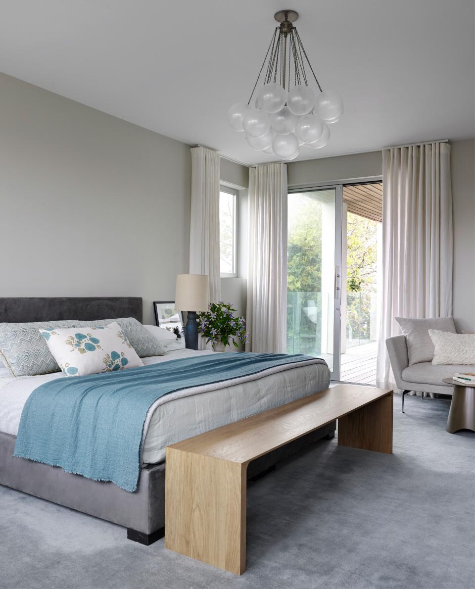 For the primary bedroom, the couple opted for a bed custom-designed by Mancini. It is anchored by an Apparatus chandelier, seen above.