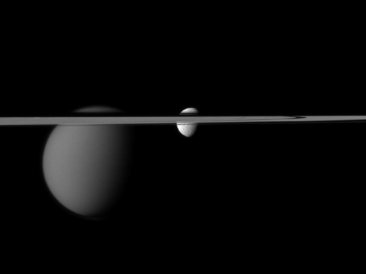 The Cassini spacecraft's view of the moons Tethys and Titan are disrupted by the rings of Saturn in this December 7, 2011 NASA handout obtained by Reuters January 13, 2012. The larger moon, Titan is on the left. This view looks toward the Saturn-facing sides of Tethys and Titan. The angle also shows the northern, sunlit side of the rings from less than one degree above the ring plane. The image was taken in visible red light with the Cassini spacecraft narrow-angle camera at a distance of approximately 3.1 million kilometer from Titan. REUTERS/NASA/JPL-Caltech/Space Science Institute/Handout  (UNITED STATES - Tags: SOCIETY SCIENCE TECHNOLOGY) FOR EDITORIAL USE ONLY. NOT FOR SALE FOR MARKETING OR ADVERTISING CAMPAIGNS. THIS IMAGE HAS BEEN SUPPLIED BY A THIRD PARTY. IT IS DISTRIBUTED, EXACTLY AS RECEIVED BY REUTERS, AS A SERVICE TO CLIENTS