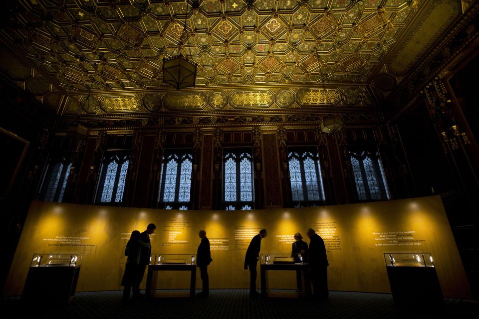 People look at the four surviving original parchment engrossments of the 1215 Magna Carta, as they are displayed to mark the 800th anniversary of the sealing of the Magna Carta in 1215, in the Queen's Robing Room at the Houses of Parliament in London February 5, 2015. The original copies were displayed on Thursday for one day at the opening of the exhibition "Magna Carta and Parliament". REUTERS/Matt Dunham/pool (BRITAIN - Tags: POLITICS SOCIETY)