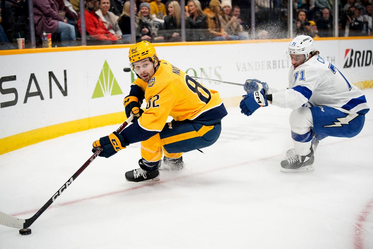 Nashville Predators center Tommy Novak (82) moves the puck past Tampa Bay Lightning center Anthony Cirelli (71) during the first period at Bridgestone Arena in Nashville, Tenn., Thursday, Dec. 7, 2023.