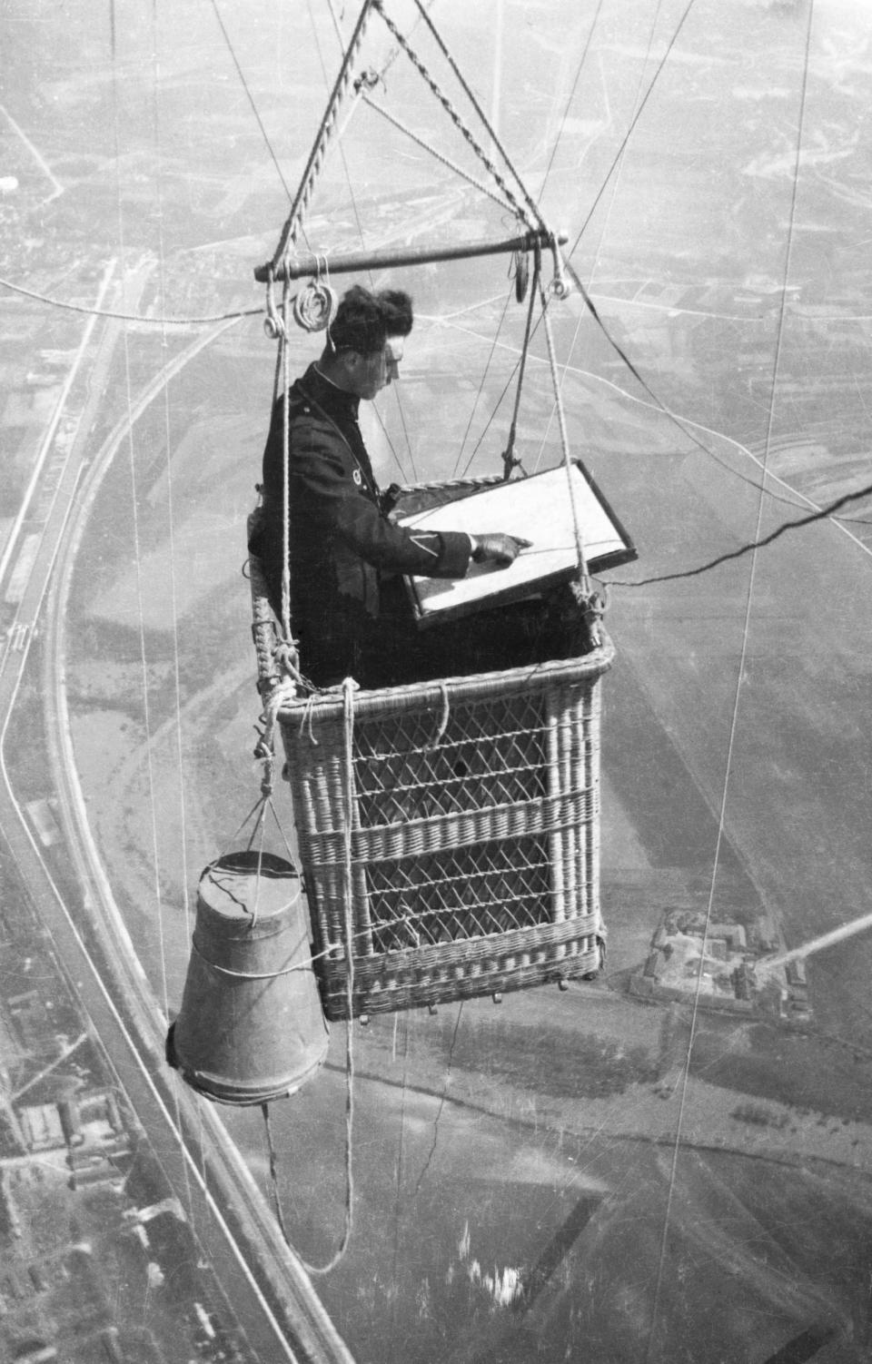 A French officer is seen mapping terrain aboard a balloon gondola as he performs aerial reconnaissance before the introduction of aerial cameras in the 1870s.