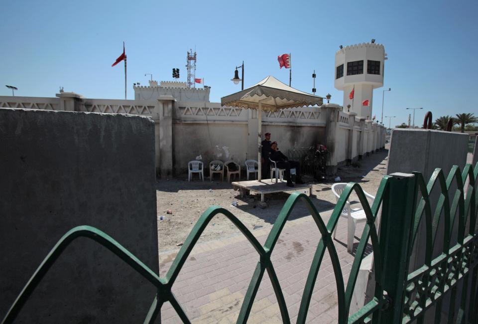 Policemen stand guard in front of a police station after it was attached by angry Bahraini anti-government protesters in Sitra, Bahrain, Tuesday, May 6, 2014. Bahraini police have confronted attackers who tried to firebomb a police post in a largely Shiite community in the tiny Gulf island nation, authorities said Tuesday. (AP Photo/Hasan Jamali)