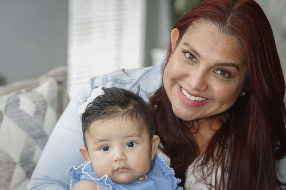 Victoria Cornejo Barrera, former head custodian for a high school in Columbia, South Carolina holds her four-month-old daughter Fernanda Cabrera at her home in Columbia, S.C., Monday, June 10, 2024. The Pregnant Workers Fairness Act entitled her to the types accommodations she had been seeking when she was pregnant. (AP Photo/Nell Redmond)