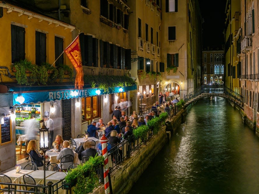 Diners outdoors at Venice canal at night