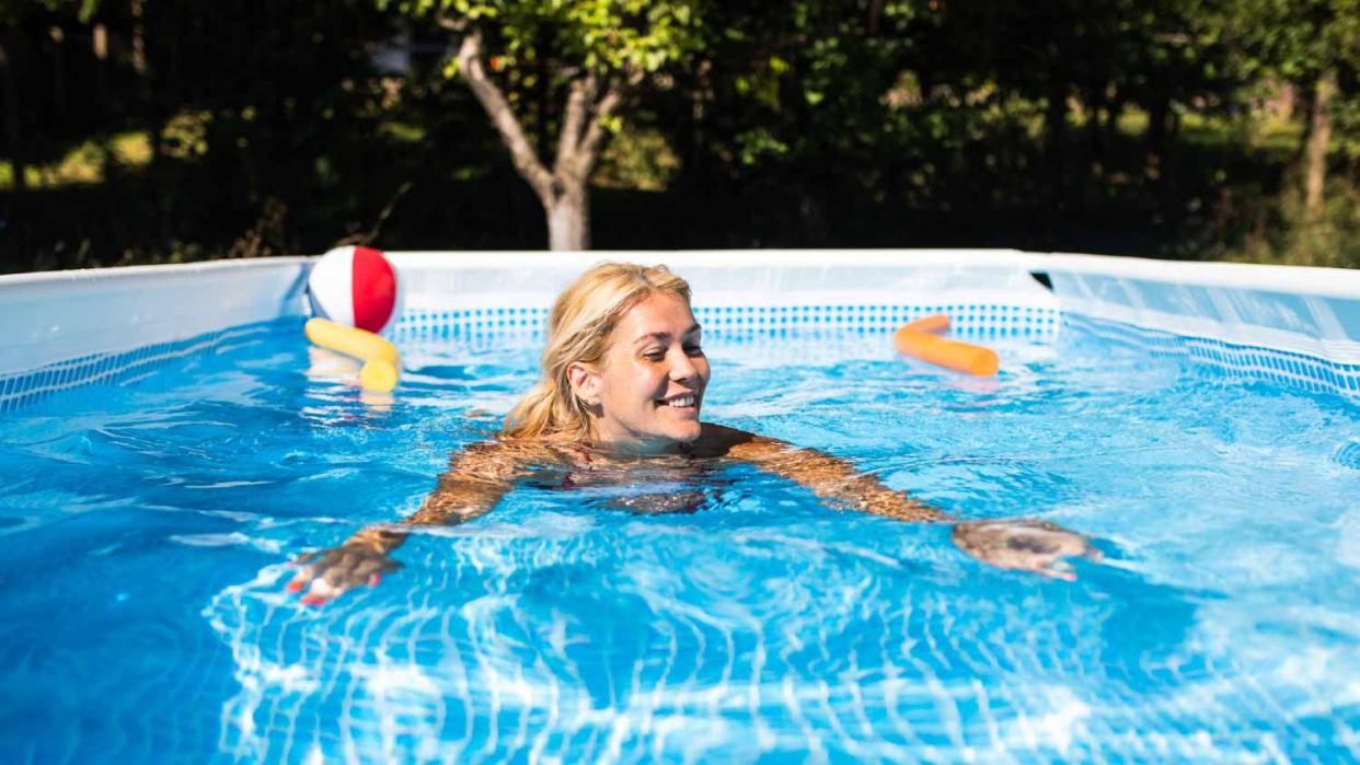 A woman swimming in an above-ground pool