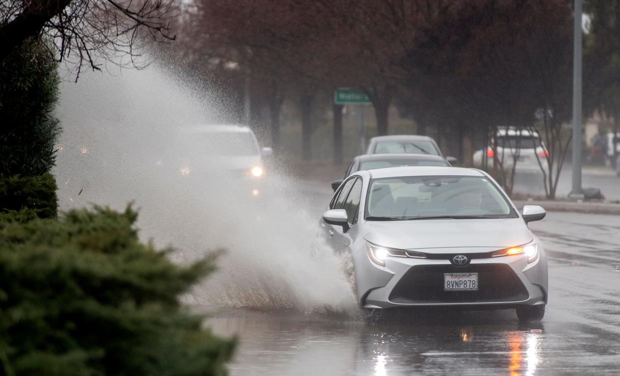 A car splashes through a large puddle left by recent storms on Hammer Lane near Alexandria Place in Stockton on Thursday, Jan. 5, 2023. 
