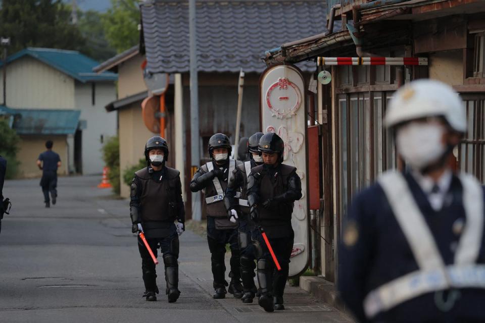 Japanese police officers are seen near the scene of a standoff where a suspect was holed up inside a building  (JIJI Press/AFP via Getty Images)