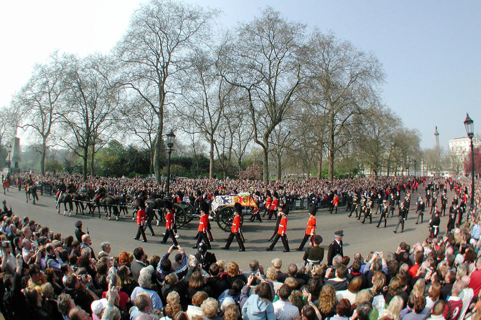 FILE - The gun carriage carrying the coffin of Britain's Queen Mother, is pulled by the Royal Horse Artillery, with members of the royal family following as it enters Horse Guards Parade on its journey to Westminster Hall, in London, Friday April 5, 2002. Hundreds of thousands of people are expected to flock to London’s medieval Westminster Hall from Wednesday, Sept. 14, 2022, to pay their respects to Queen Elizabeth II, whose coffin will lie in state for four days until her funeral on Monday. (AP Photo/Rebecca Naden/Pool, File)