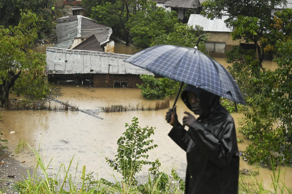 A man passes houses that are submerged in flood waters in Blantyre, Malawi Tuesday, March 14, 2023. The unrelenting Cyclone Freddy that is currently battering southern Africa has killed more than 50 people in Malawi and Mozambique since it struck the continent for a second time on Saturday night, (AP Photo/Thoko Chikondi)