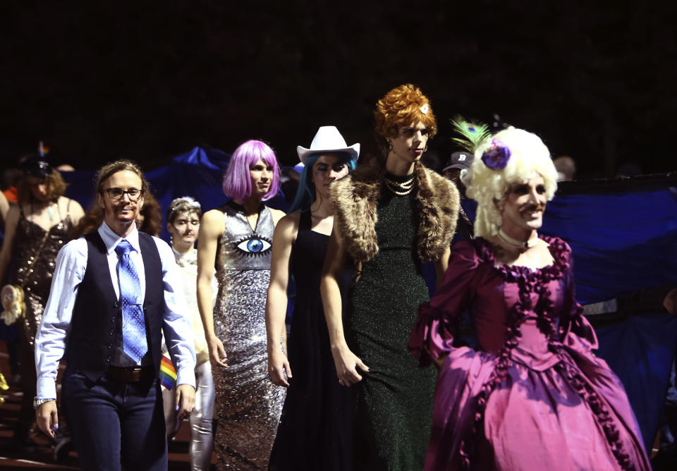 In this photo provided by Fritz Senftleber, people participate in the “drag ball" halftime show at Burlington High School on Friday, Oct. 15, 2021 in Burlington, Vt. The event was part of that school's homecoming and was sponsored by the Gender Sexuality Alliance from Burlington and South Burlington high schools. The football game was between a team made up of students from three Burlington-area schools Burlington, South Burlington and Winooski High Schools who played against St. Johnsbury Academy. (Fritz Senftleber via AP)