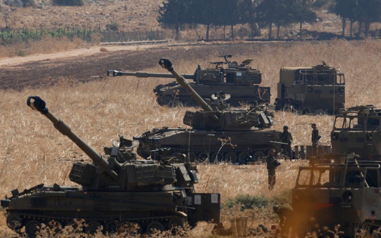 Israeli soldiers sit next artillery units deployed in Hula Valley north of Israel near the Israeli-Lebanon border - REX