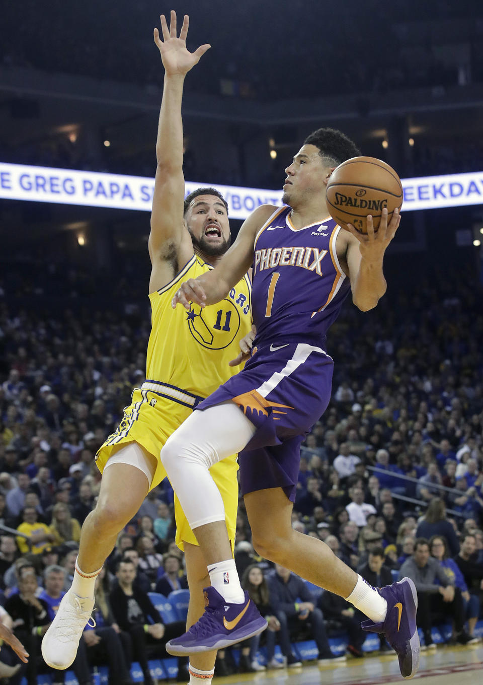 Phoenix Suns guard Devin Booker (1) shoot against Golden State Warriors guard Klay Thompson (11) during the first half of an NBA basketball game in Oakland, Calif., Sunday, March 10, 2019. (AP Photo/Jeff Chiu)