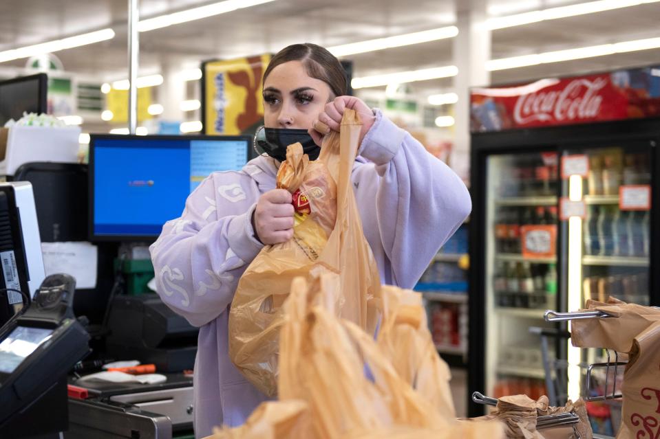 Cashier Hailey Sweeney of Bristol helps customers check out at Selecto Supermarket in Bristol on Monday, Nov. 7, 2022.