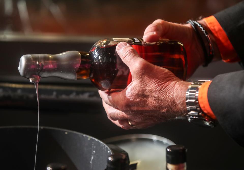 Evan Williams Bourbon Experience Artisanal Distiller Jodie Filiatreau dipped commemorative bourbon bottles with the 150th Kentucky Derby Festival pin during a media event Friday morning at the Main Street distillery.