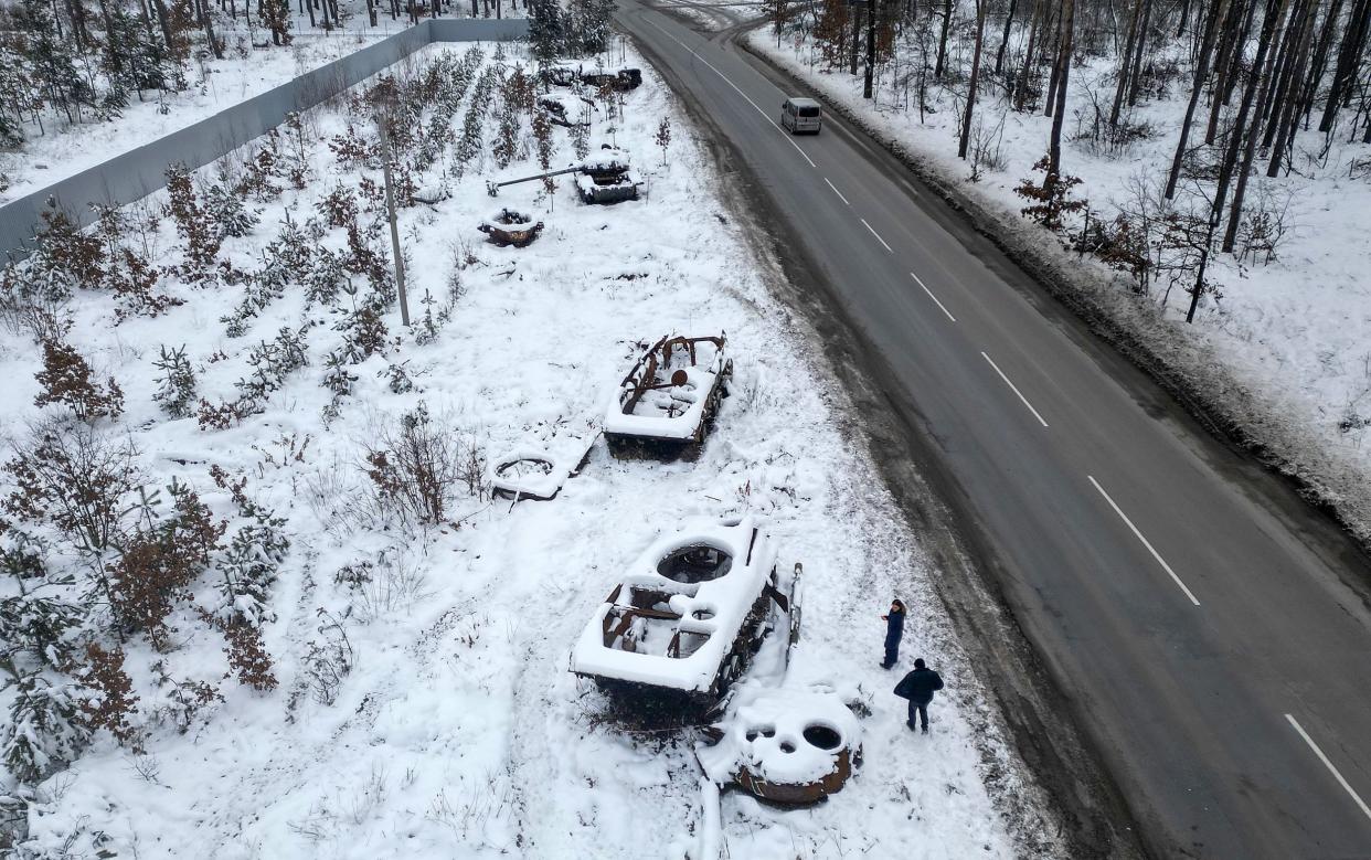 A man views destroyed Russian tanks outside Bucha in Bucha, Ukraine - Jeff J Mitchell