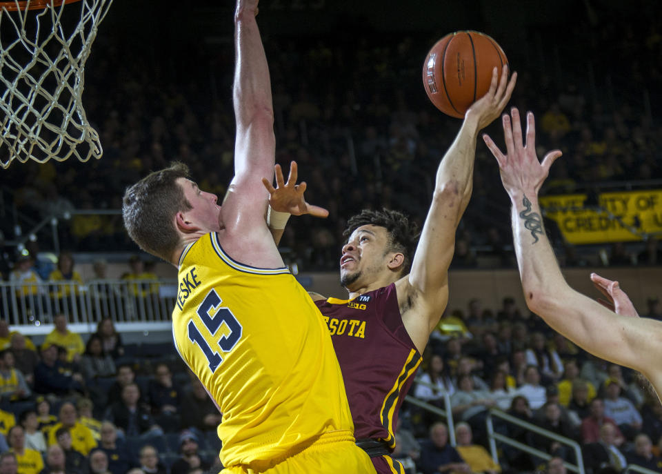 Michigan center Jon Teske (15) defends a shot attempt from Minnesota guard Amir Coffey, right, in the first half of an NCAA college basketball game at Crisler Center in Ann Arbor, Mich., Tuesday, Jan. 22, 2019. (AP Photo/Tony Ding)