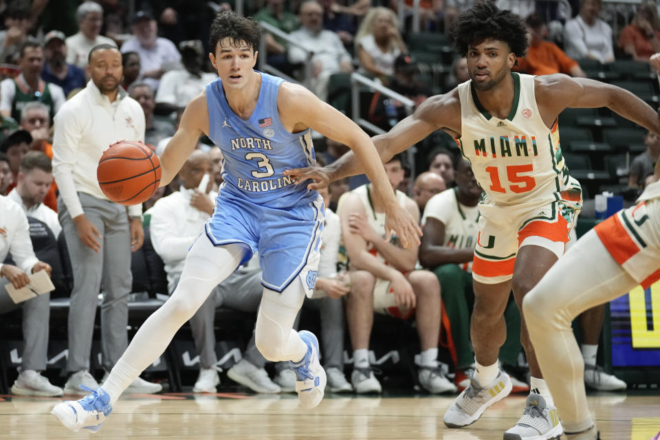 North Carolina guard Cormac Ryan (3) dribbles downcourt defended by Miami forward Norchad Omier (15) during the first half of an NCAA college basketball game, Saturday, Feb. 10, 2024, in Coral Gables, Fla. (AP Photo/Rebecca Blackwell)