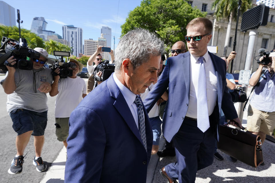 Carlos De Oliveira, center, an employee of Donald Trump's Mar-a-Lago estate, arrives for a court appearance with attorney John Irving, at the James Lawrence King Federal Justice Building, Monday, July 31, 2023, in Miami. De Oliveira, Mar-a-Lago's property manager, was added last week to the indictment with Trump and the former president's valet, Walt Nauta, in the federal case alleging a plot to illegally keep top-secret records at Trump's Florida estate and thwart government efforts to retrieve them. (AP Photo/Wilfredo Lee)