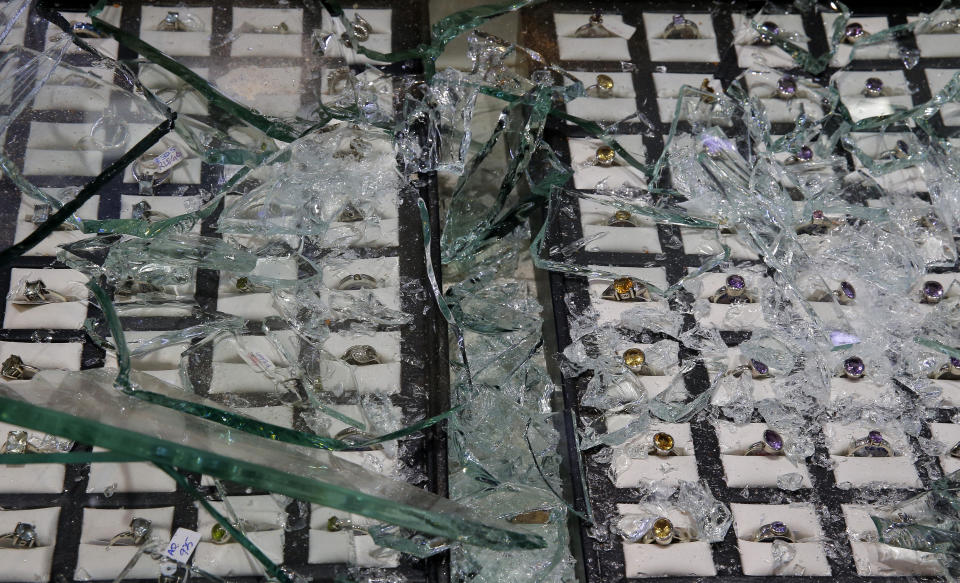 Glass pieces lay scattered over jewelry after the showroom owned by a muslim trader was vandalized in Poruthota, a village in Negombo, about 35 kilometers North of Colombo, Sri Lanka, Monday, May 6, 2019. Two people have been arrested and an overnight curfew lifted Monday after mobs attacked Muslim-owned shops and some vehicles in a Sri Lankan town where a suicide bombing targeted a Catholic church last month. Residents in the seaside town of Negombo say the mostly-Catholic attackers stoned and vandalized shops. It is unclear how the dispute began but most residents say a private dispute took a religious turn. (AP Photo/Eranga Jayawardena)