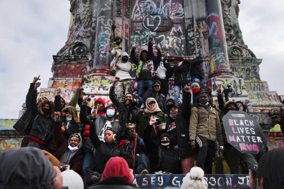 Black Lives Matters supporters pose at a statue of Confederate leader Robert E. Lee