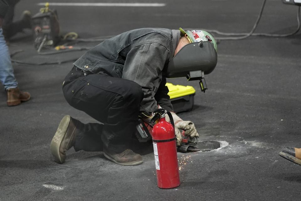 Un trabajador busca reparar una alcantarilla tras la cancelación de la primera práctica para el Gran Premio de Las Vegas, el jueves 16 de noviembre de 2023 (AP Foto/Nick Didlick)