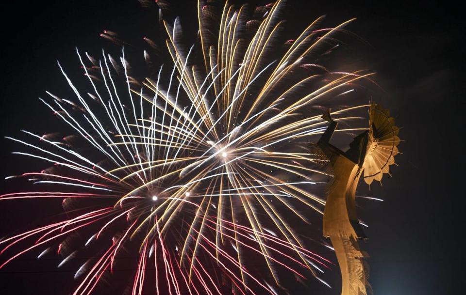 A Fourth of July fireworks display explodes behind the Keeper of the Plains statue in downtown Wichita.