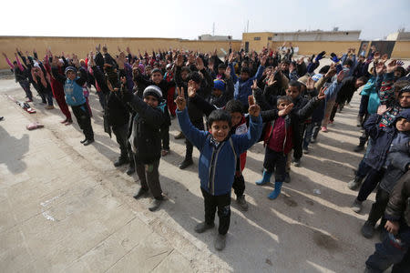 Students gesture as they stand in line at the 'Aisha Mother of the BelieversÕ school which was recently reopened after rebels took control of al-Rai town from Islamic State militants, Syria January 16, 2017. Picture taken January 16, 2017. REUTERS/Khalil Ashawi