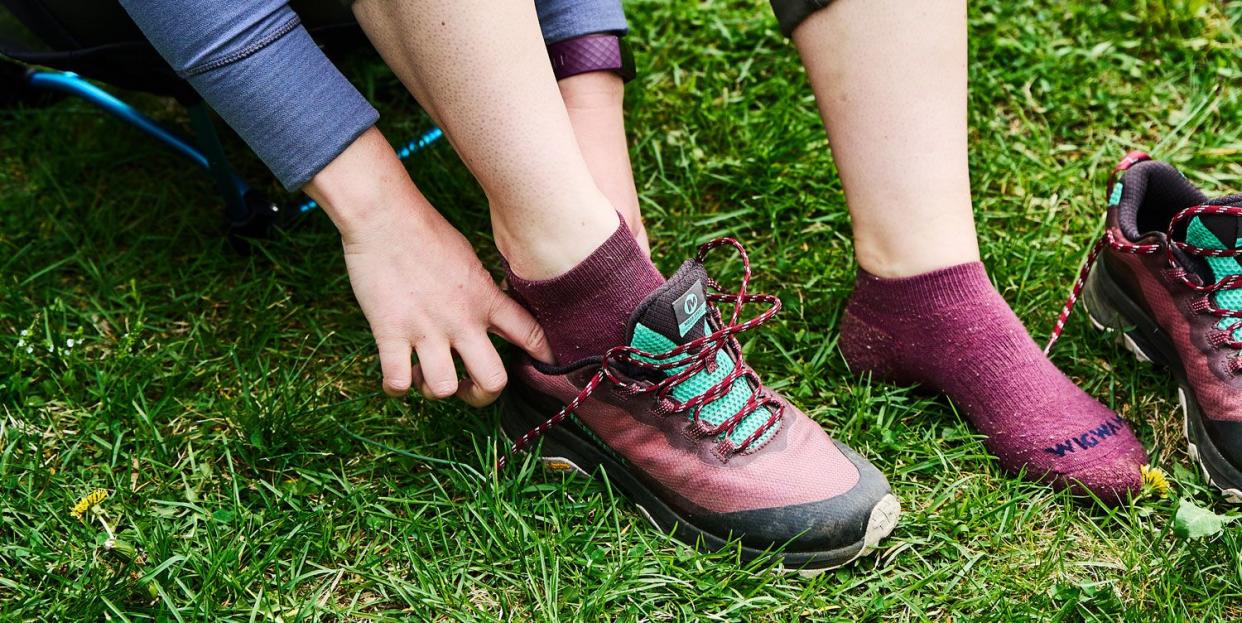 woman wearing hiking socks and putting on a pair of hiking shoes