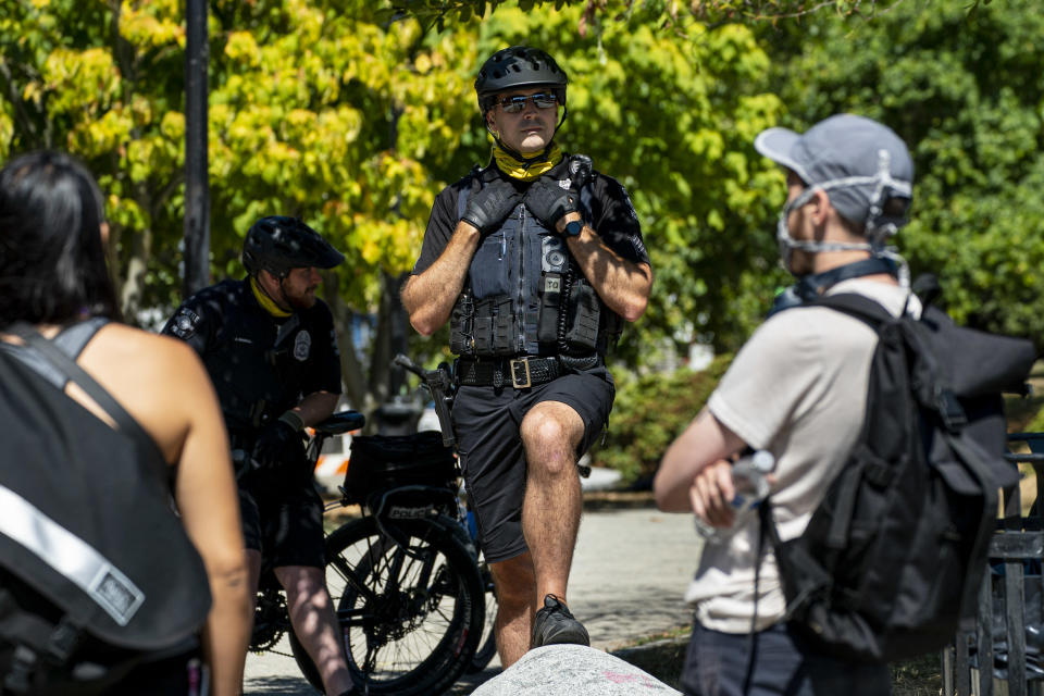 Seattle police officers stand in front of protesters on Aug. 14 after police conducted a sweep of Cal Anderson Park in the area formerly known as CHOP. (David Ryder/Getty Images)